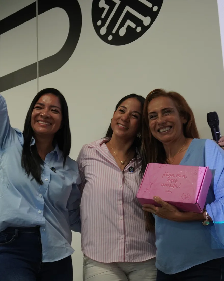 Liz Henao en un evento presencial, celebrando junto a dos mujeres emprendedoras